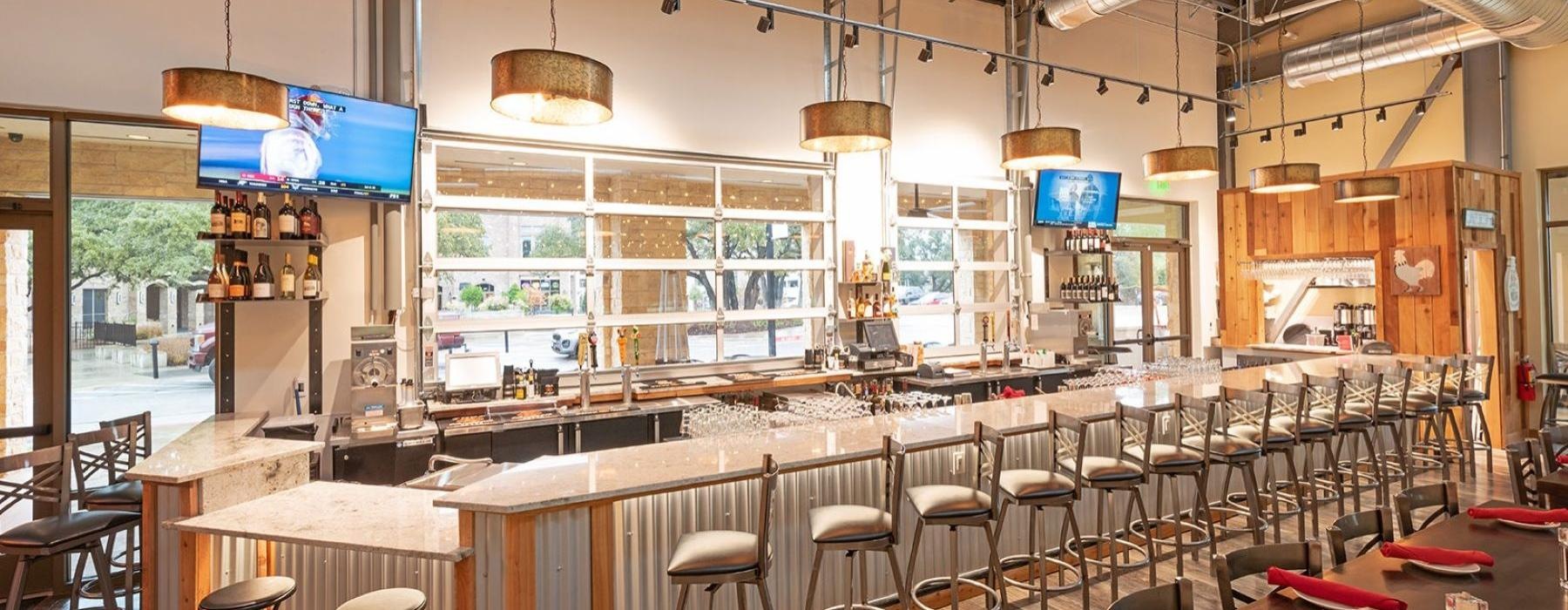 a bar with stools and tables